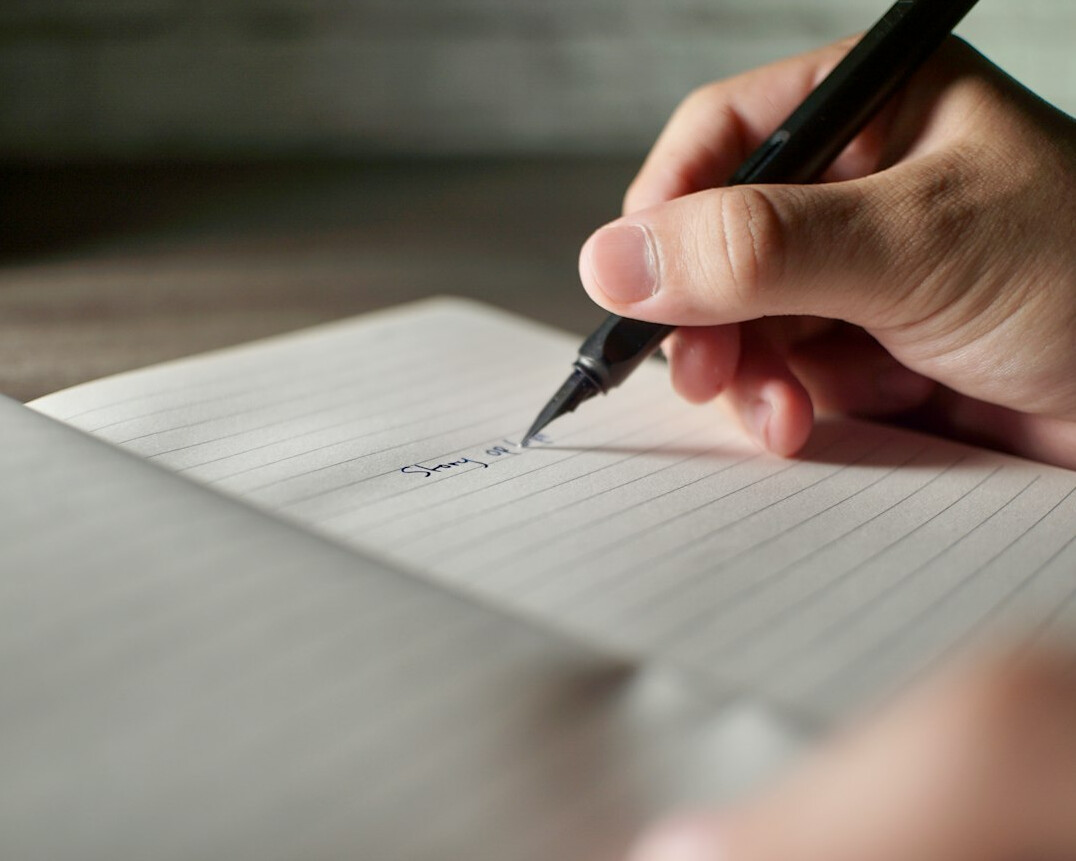 person writing in journal