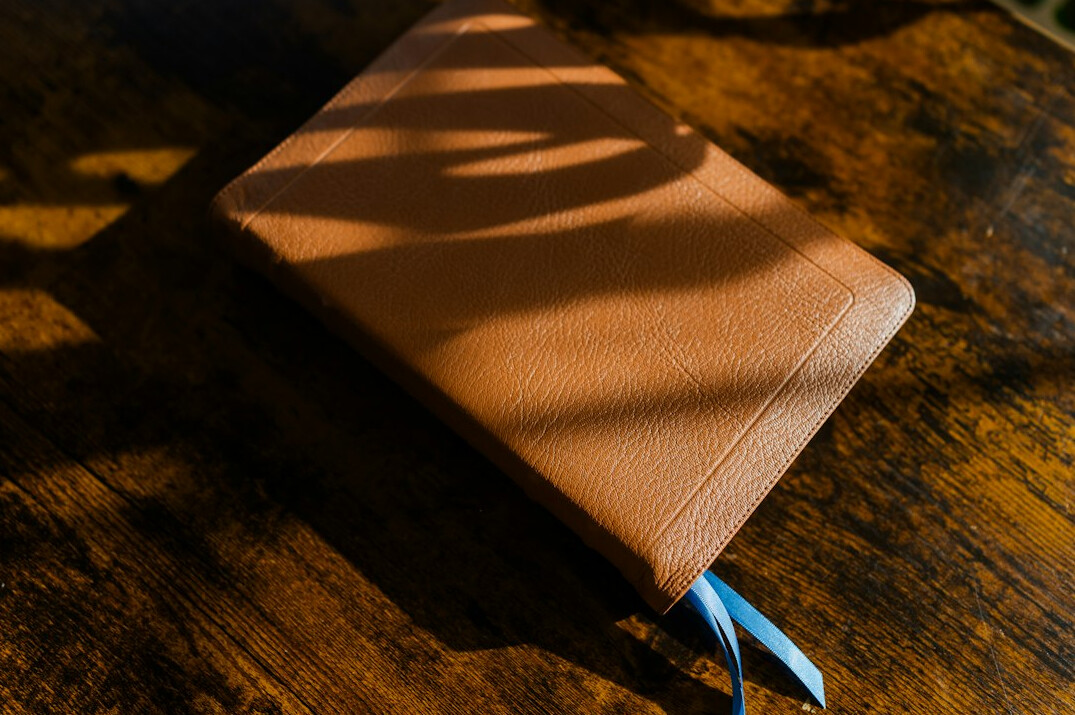 Open notebook with a pen on a wooden table in warm light